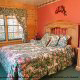 Country bedroom with floral decor in cabin 30 (Mountain Refuge), in Pigeon Forge, Tennessee.
