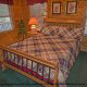 This bedroom has two windows to let nature in in cabin 75 (Palmetto Place), in Pigeon Forge, Tennessee.