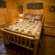 Curl up in this log bed in this nicely furnished bedroom in cabin 79 (Robyns Nest), in Pigeon Forge, Tennessee. 