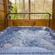 This hot tub is alluring with its forest view in cabin 83 (Sweet Serenity), in Pigeon Forge, Tennessee.