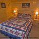 Bedroom with Two Night Stands in Cabin 860 (Cozy Bear Overlook) at Eagles Ridge Resort at Pigeon Forge, Tennessee.